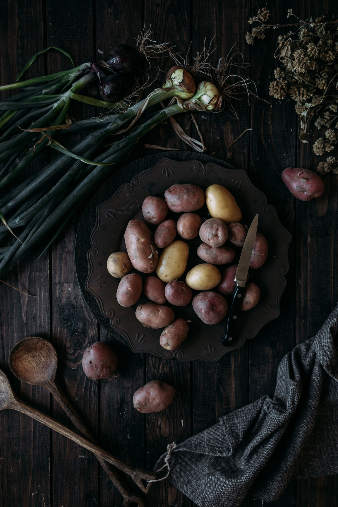 Red potatoes and onions on dark wooden background